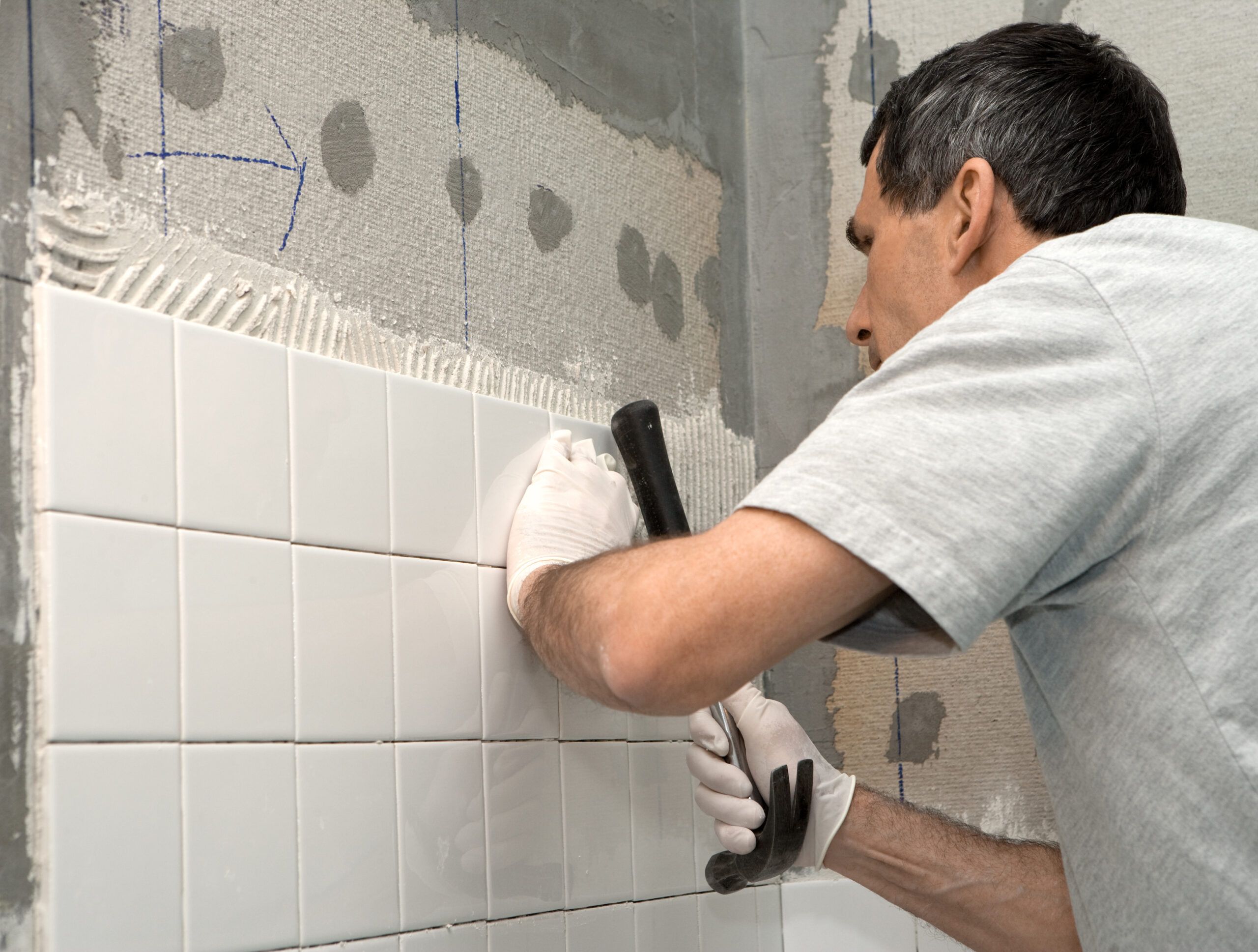 Man Tiling A Bathroom Wall